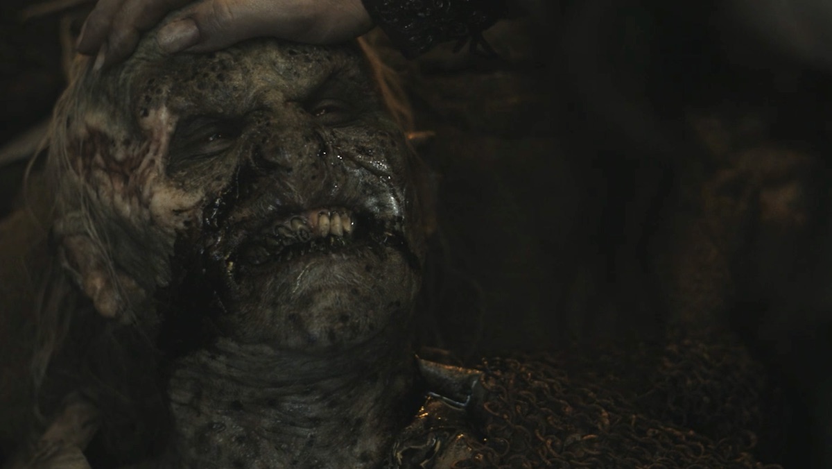 A dying orc smiles at Adar as he holds the orcs head on The rIngs of Power