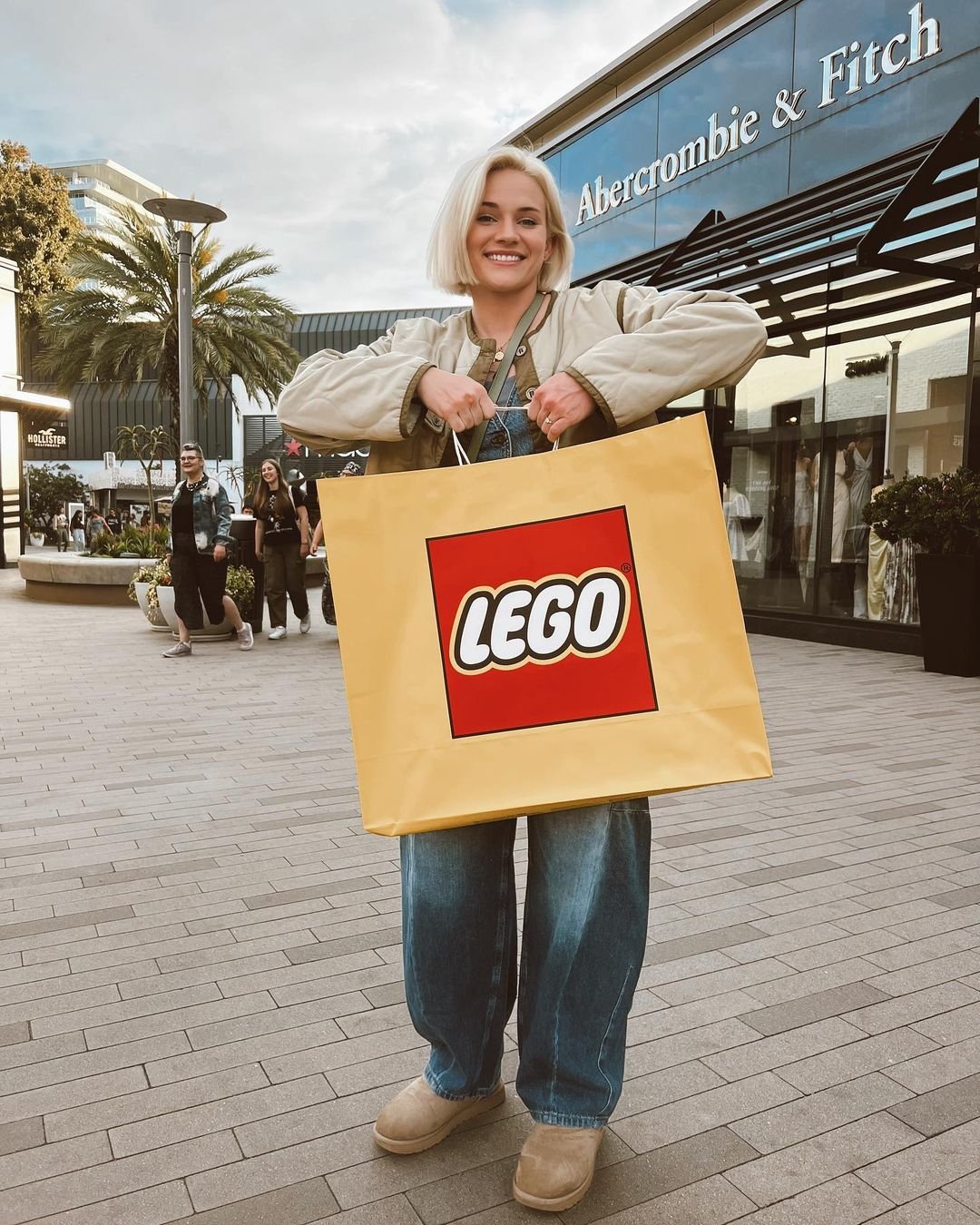 Olympic medalist Sammy Sullivan holding a yellow and red LEGO bag