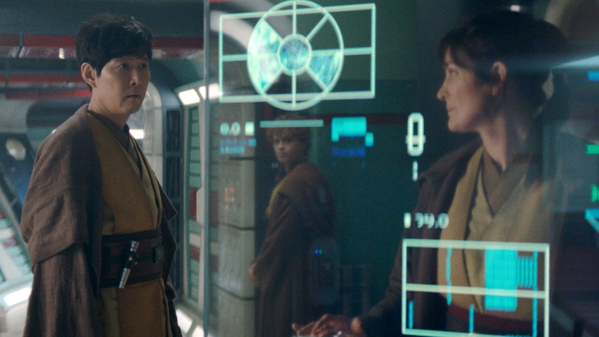 Sol speaks to Indara with Torbin in the background behind a glass monitor on The Acolyte