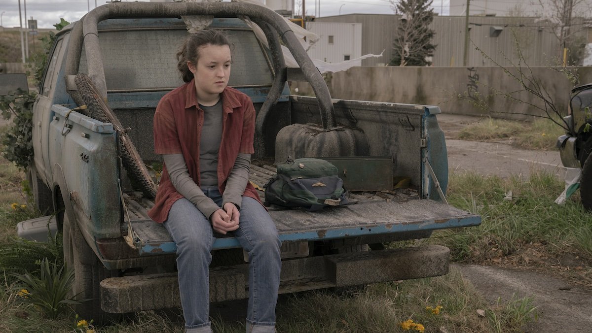 Bella Ramsey's Ellie sits on the back of a pickup truck on The Last of Us